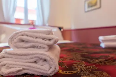 a stack of towels sitting on top of a bed at Vatican Night Suites in Rome