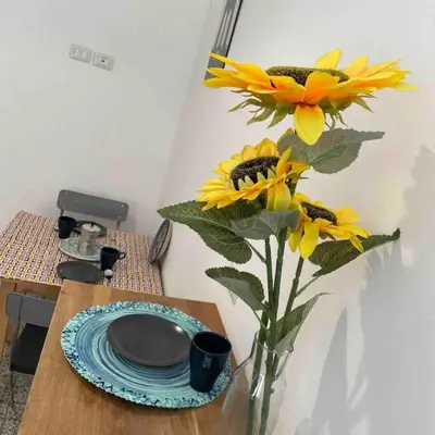 a vase of yellow flowers sitting on a table at K-Celimontana Apartment in Rome
