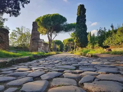 a cobblestone road with trees on the side at K-Celimontana Apartment in Rome
