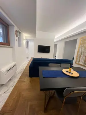 a living room with a blue couch and a table at Savoia House, modern apartment near Villa Borghese in Rome