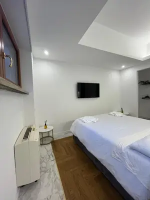 a white bedroom with a bed and a tv at Savoia House, modern apartment near Villa Borghese in Rome