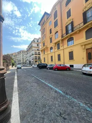 a cobblestone street with cars parked in front of buildings at Savoia House, modern apartment near Villa Borghese in Rome