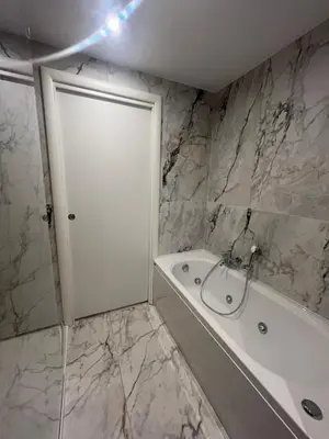 a bathroom with a white tub and a white door at Savoia House, modern apartment near Villa Borghese in Rome