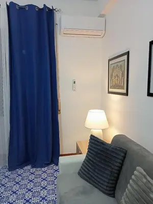 a blue curtain in a living room with a couch at House Vaticano in Rome