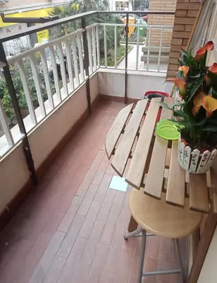a balcony with a wooden bench and a table with a plant at House Vaticano in Rome