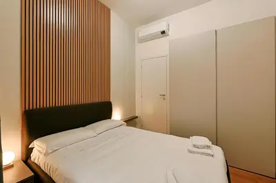 a bedroom with a white bed with a black headboard at Ottaviano Design Apartment at the Vatican in Rome