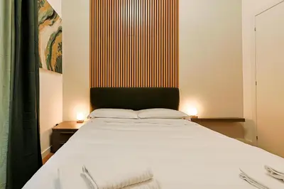 a bedroom with a large white bed with two towels at Ottaviano Design Apartment at the Vatican in Rome