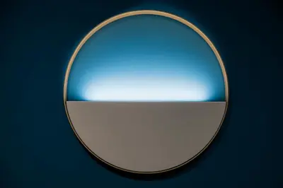 a mirror with a reflection of a blue at Ottaviano Design Apartment at the Vatican in Rome