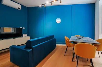 a blue living room with a table and a couch at Ottaviano Design Apartment at the Vatican in Rome