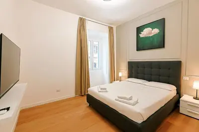 a bedroom with a bed and a flat screen tv at Ottaviano Design Apartment at the Vatican in Rome