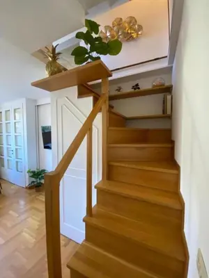 a stairway with a wooden rail and a door at Margutta Domitia Home in Rome