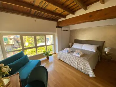 a bedroom with a bed and a blue couch at Margutta Domitia Home in Rome