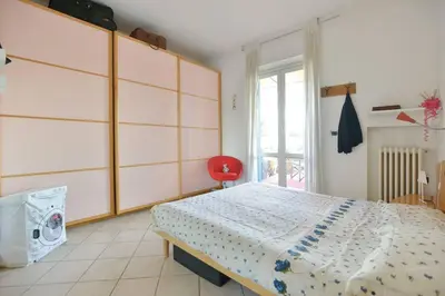 a bedroom with a large bed and a red chair at SUPER SUNNY PENTHOUSE WITH TERRACE in Rome
