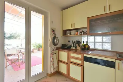 a kitchen with yellow cabinets and a sliding glass door at SUPER SUNNY PENTHOUSE WITH TERRACE in Rome