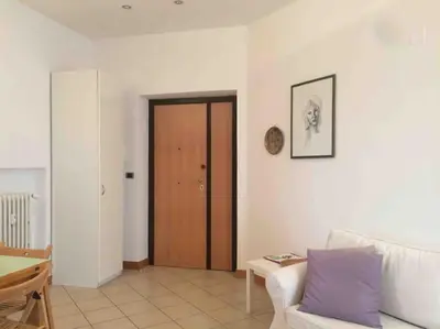 a living room with a couch and a wooden door at SUPER SUNNY PENTHOUSE WITH TERRACE in Rome