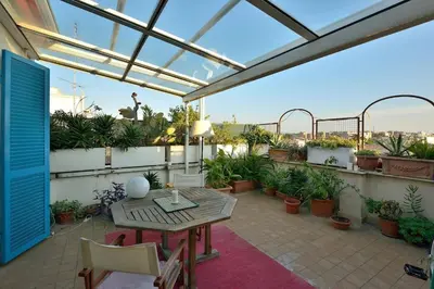 a patio with a table and chairs and potted plants at SUPER SUNNY PENTHOUSE WITH TERRACE in Rome
