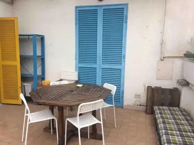 a wooden table and chairs in front of a blue shutter at SUPER SUNNY PENTHOUSE WITH TERRACE in Rome