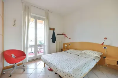 a bedroom with a bed and a red chair at SUPER SUNNY PENTHOUSE WITH TERRACE in Rome