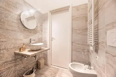 a white bathroom with a sink and a mirror at Charming Apartment in the centre of Rome in Rome
