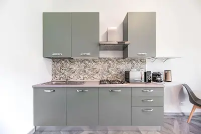 a kitchen with white cabinets and a stove at Charming Apartment in the centre of Rome in Rome