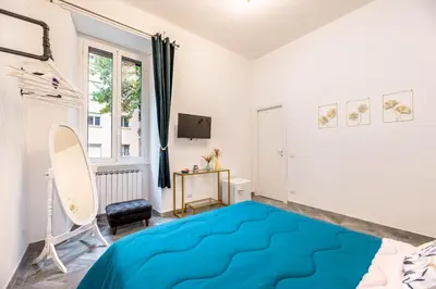 a bedroom with a blue bed and a tv at Charming Apartment in the centre of Rome in Rome