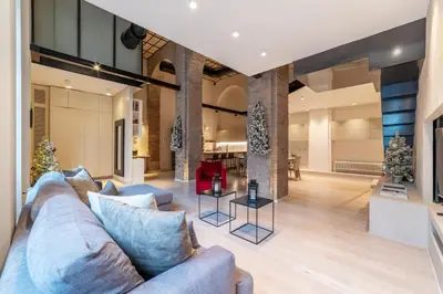 a living room with a blue couch and christmas trees at Luxury Loft next to Via Veneto in Rome