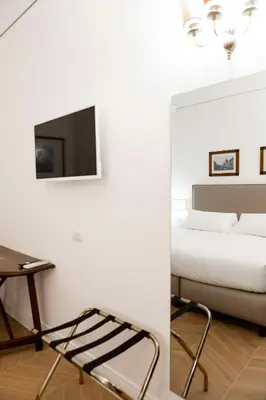 a bedroom with a bed and a tv on a wall at Domus Vitra in Rome