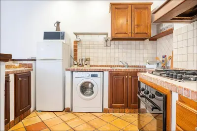 a kitchen with a white refrigerator and a washing machine at Attico Campo de Fiori Katia in Rome