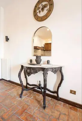 a table with a mirror on a wall at Attico Campo de Fiori Katia in Rome