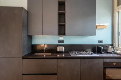 a kitchen with white cabinets and a counter top at Loft Porta Maggiore in Rome