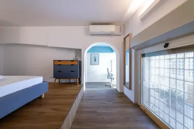 a bedroom with a bed and a large window at Loft Porta Maggiore in Rome