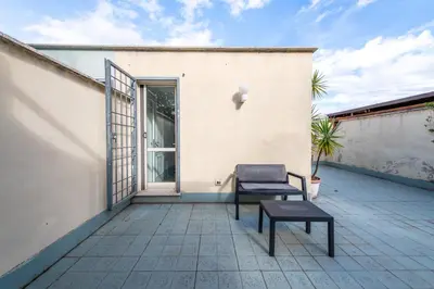 a patio with a chair and a table at Loft Porta Maggiore in Rome