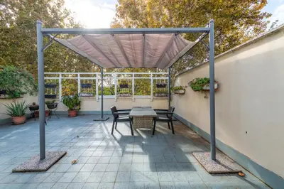 a pergola with a table and chairs on a patio at Loft Porta Maggiore in Rome