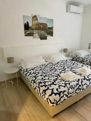 a bedroom with two beds and a painting on the wall at Dolce Vita Rooms Monteverde Trastevere in Rome