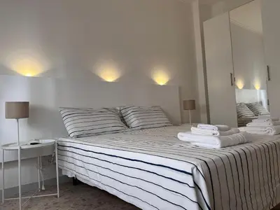a white bedroom with a bed with towels on it at Dolce Vita Rooms Monteverde Trastevere in Rome