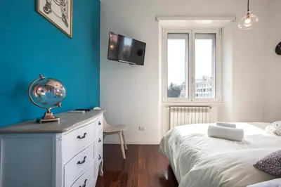 a bedroom with a white bed and a blue wall at Piramide Family Apartment Rome in Rome