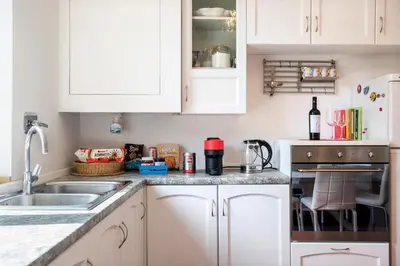 a kitchen with white cabinets and a sink at Piramide Family Apartment Rome in Rome