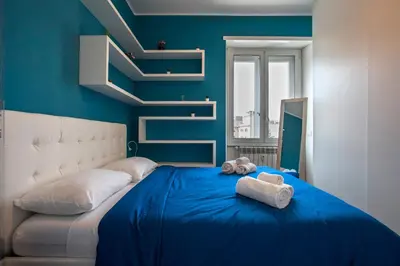 a blue bedroom with a bed with towels on it at Piramide Family Apartment Rome in Rome