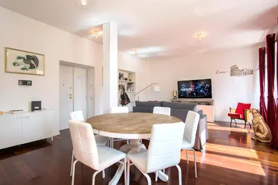 a dining room with a table and white chairs at Piramide Family Apartment Rome in Rome