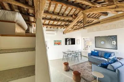 a living room with a blue couch and a table at Casa Adriana, a Burghesius home in Rome