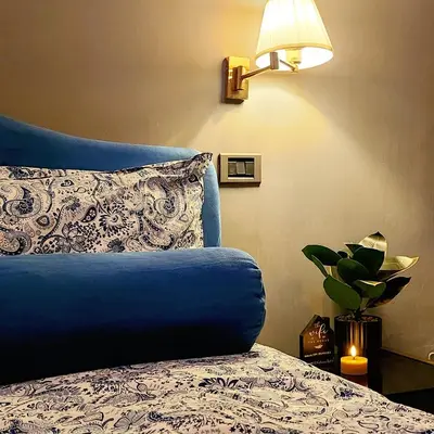 a bedroom with a blue bed with a pillow and a lamp at Vatican Stairs Apartment in Rome