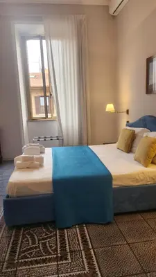 two beds in a room with a window at Vatican Stairs Apartment in Rome