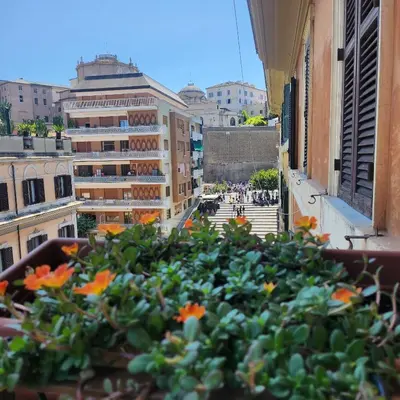 a view of a city from a balcony with flowers at Vatican Stairs Apartment in Rome