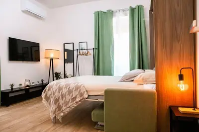 a bedroom with a large bed with green curtains at Re di Roma apartment in Rome