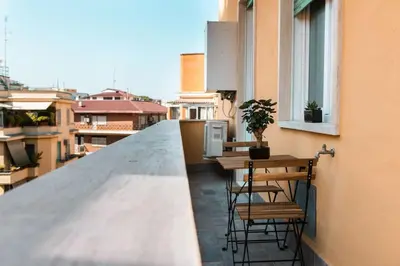 a balcony with two tables and chairs on a building at Re di Roma apartment in Rome