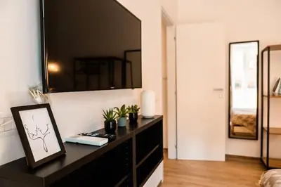 a living room with a black dresser and a mirror at Re di Roma apartment in Rome