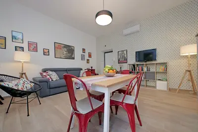 a living room with a table and chairs and a couch at YCH-Brand new Vatican flat with terrace in Rome