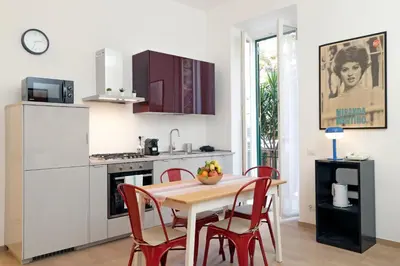a kitchen with a wooden table and red chairs at YCH-Brand new Vatican flat with terrace in Rome