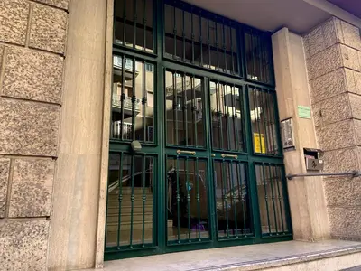 a building with glass doors with a dog inside at Mate's Apartment in Rome