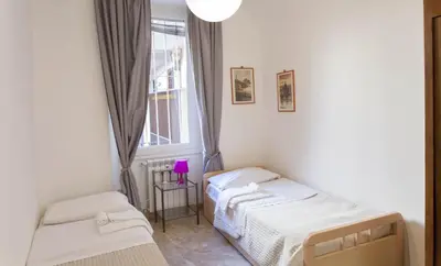 two beds in a room with a window at Between Termini & Colosseo in Rome